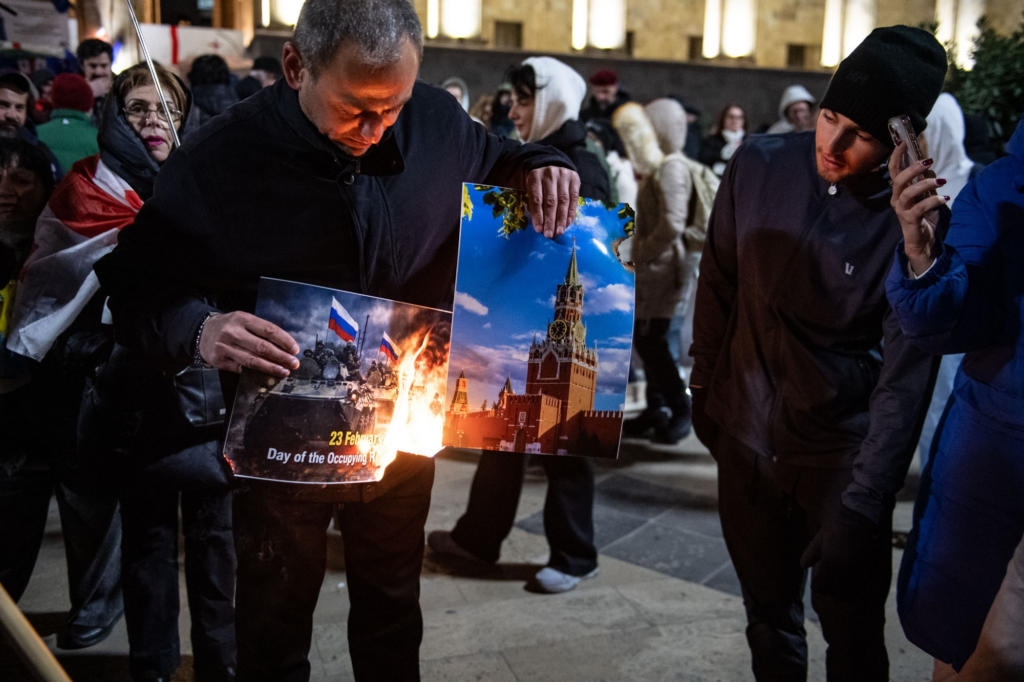 Protesters burning photo of Kremlin and photo of russian tank