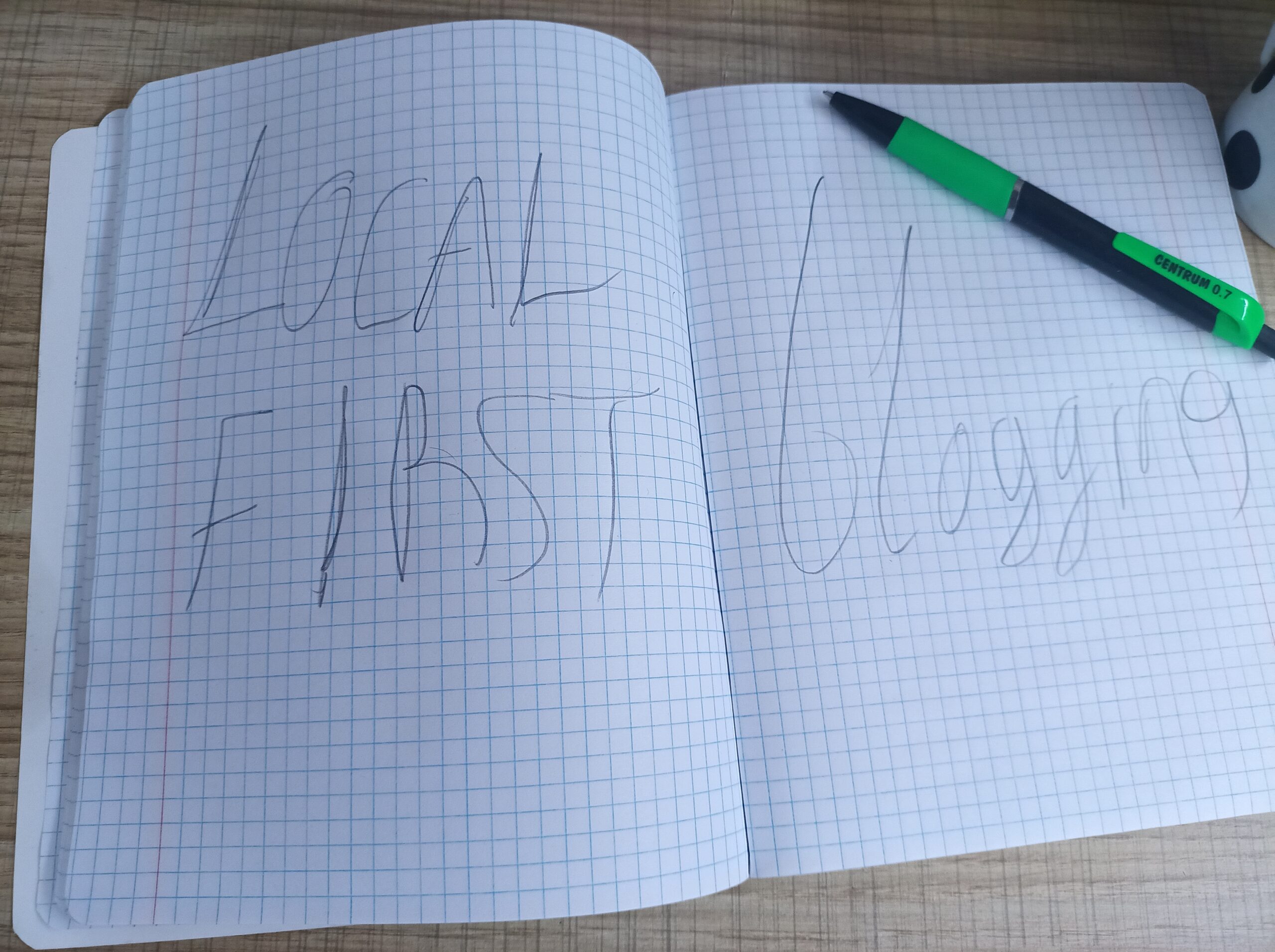 A photo of opened notebook with words Local First on left page and Blogging on right page